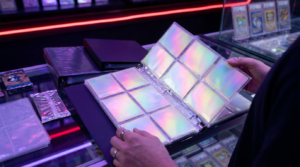 A collector's binder page glowing under purple and magenta neon light in a moody card shop