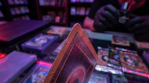 Close-up of a sleeved trading card being inspected under purple and magenta neon light